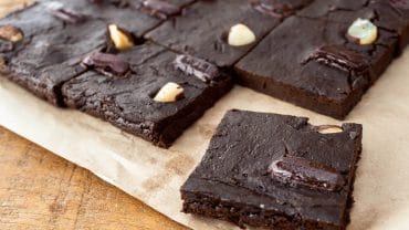 pedaços de brownie sem açúcar em uma mesa de madeira, sob um papel pardo