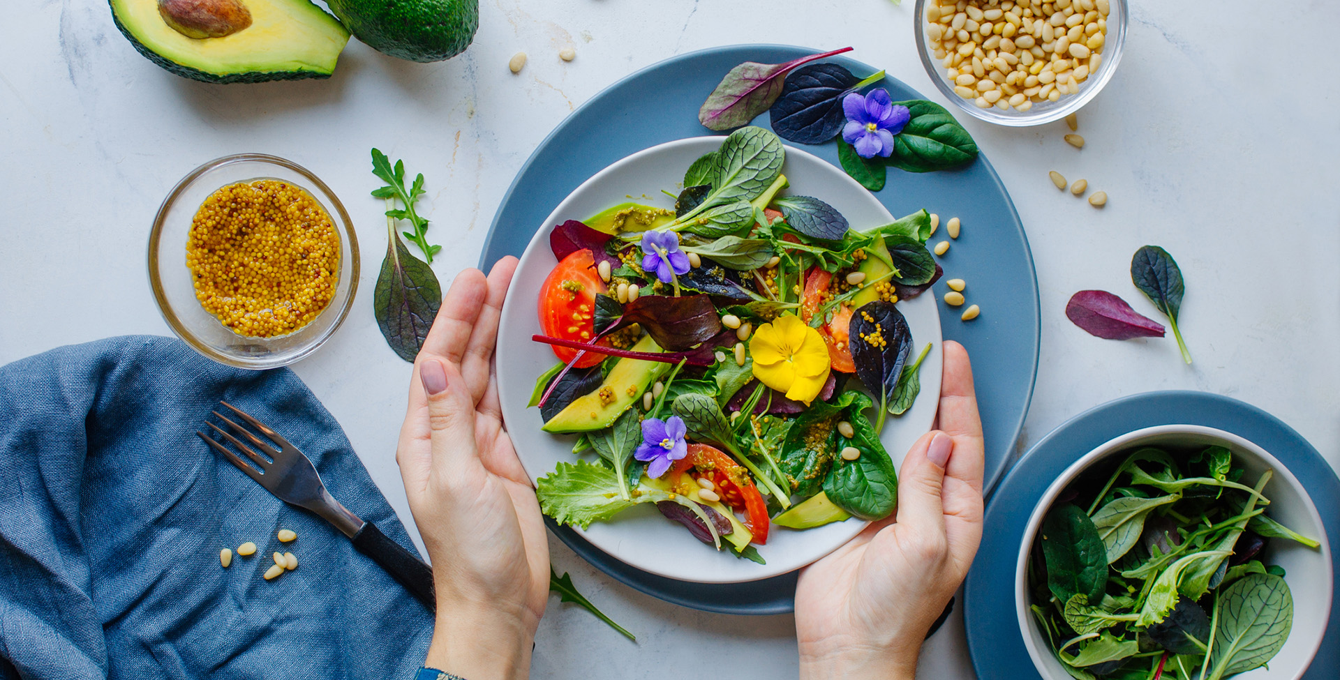 Young woman eating fresh healthy salad with edible flowers