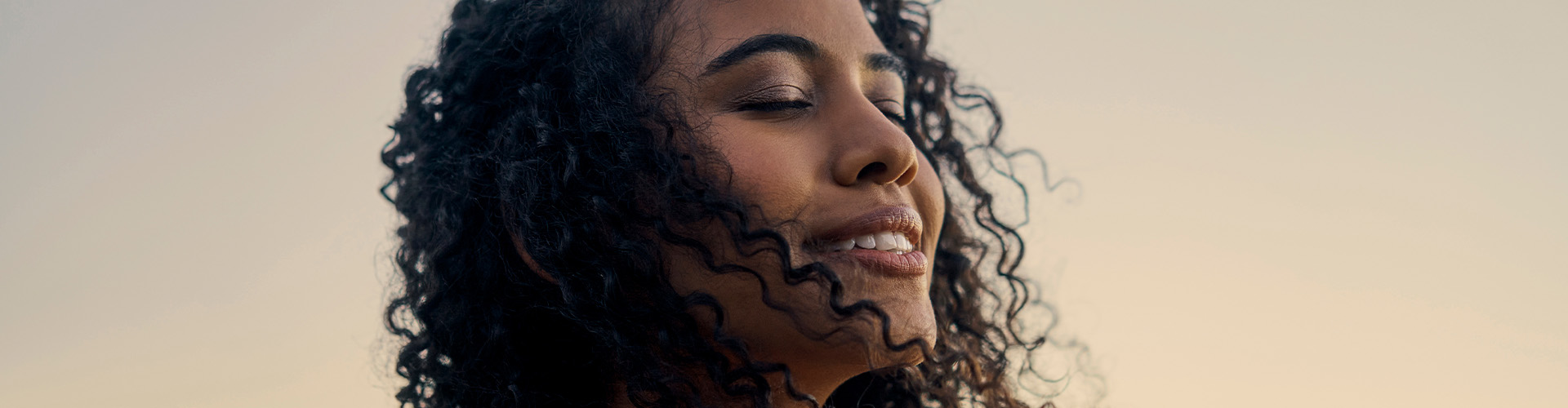 mulher de olhos fechados, com a expressão de calma e tranquilidade.